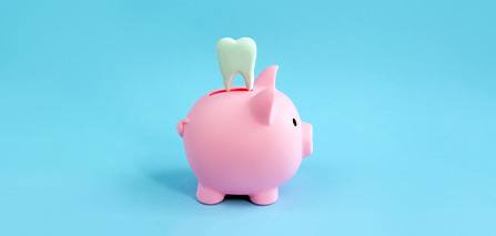 A pink piggy bank and decorative tooth on a blue background