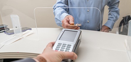 A man using a credit card to pay the cost of dental care