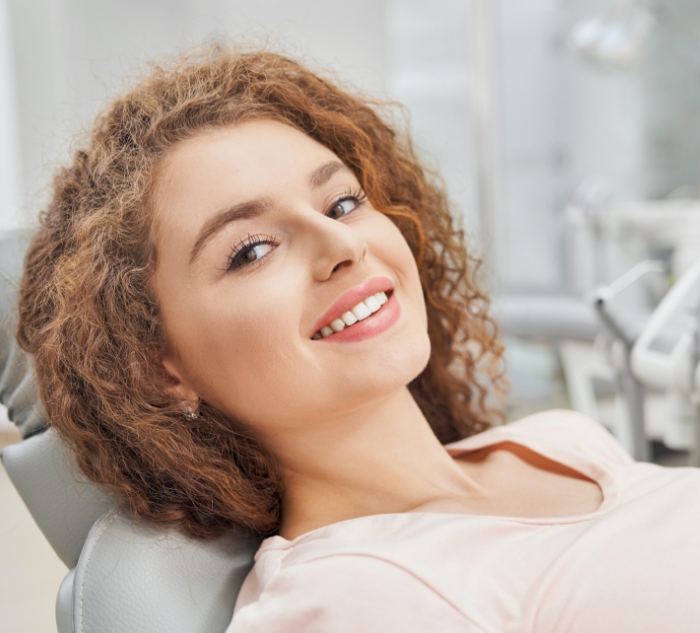 Woman leaning back in dental chair in Putnam dental office