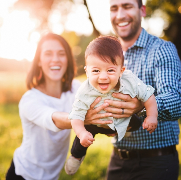 Mother and father holding their laughing baby