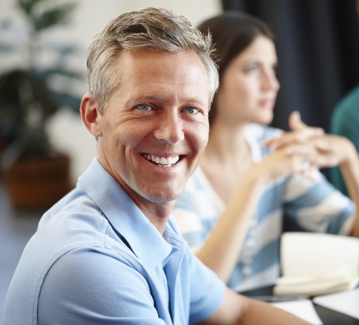 Man in blue polo shirt smiling after cosmetic dentistry in Putnam