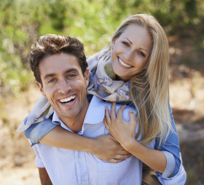 Man and woman hugging outdoors after receiving dental services in Putnam