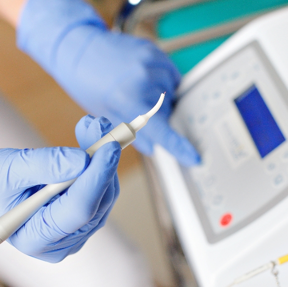 Dentist holding a small soft tissue laser pen