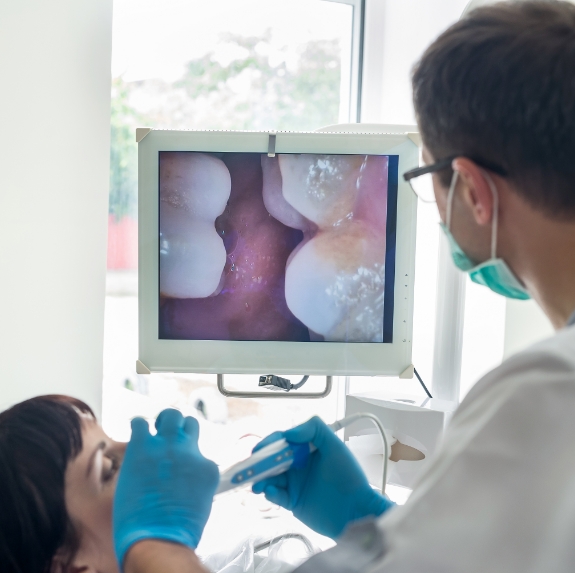 Dentist showing a patient close up photos of their teeth