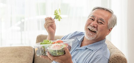 Patient in Putnam eating with dentures