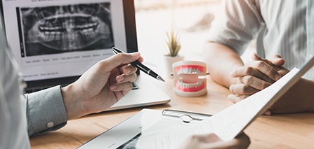 a dentist consulting with a patient about getting dentures