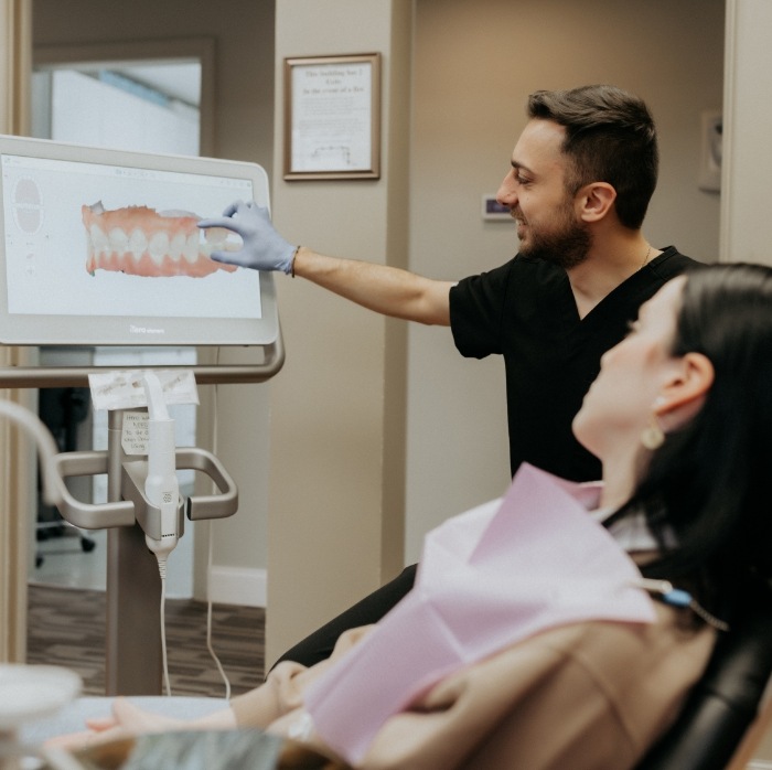 Doctor Zakhem showing a patient digital models of their teeth on a screen