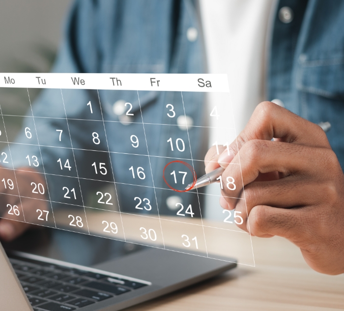 Person circling date of dental appointment on calendar