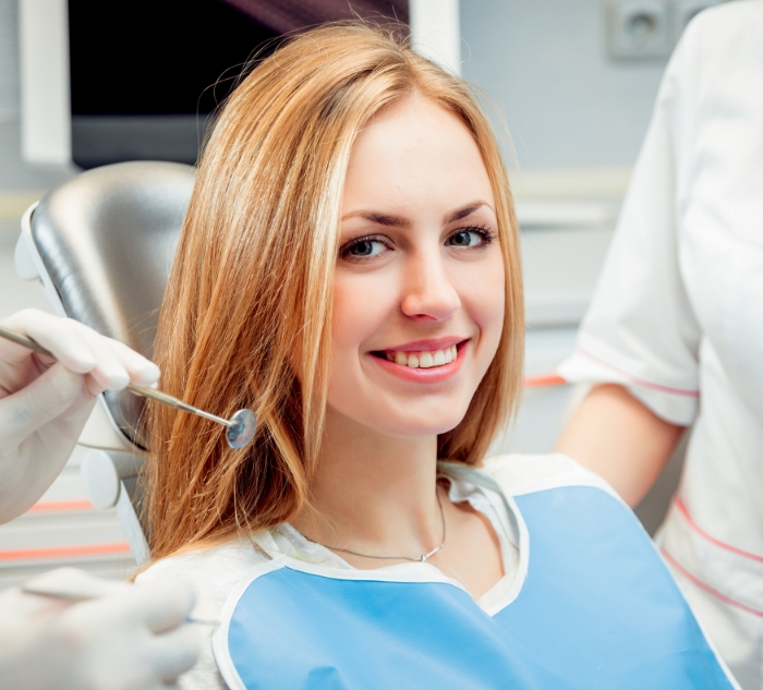 Young woman smiling in dental chair after restorative dentistry in Putnam