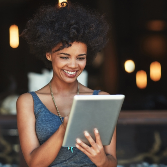 Woman smiling while looking at tablet