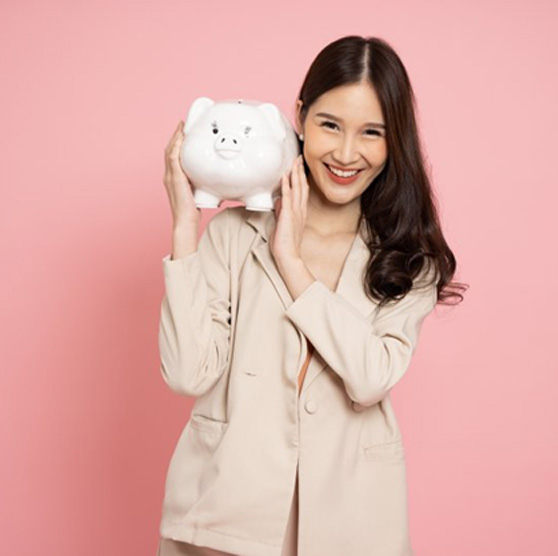 Woman holding a piggy bank over her shoulder