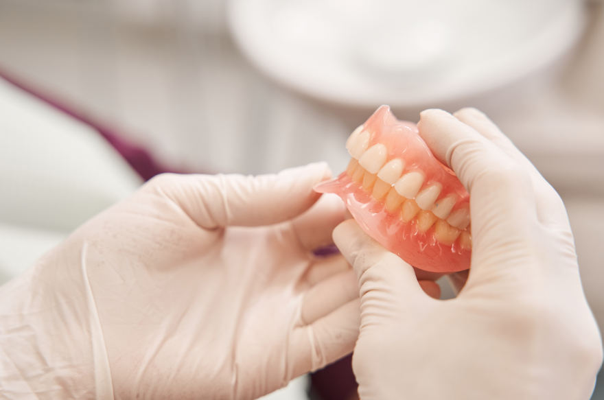 Dentist holding dentures